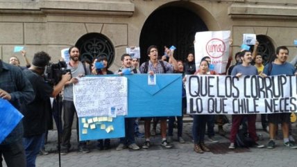 Jóvenes protestan fuera de edificio en que declara Ena von Baer